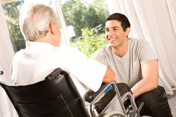 Ein Mann im Rollstuhl spricht mit einem Mitarbeiter des Ambulanten Pflegedienstes.
