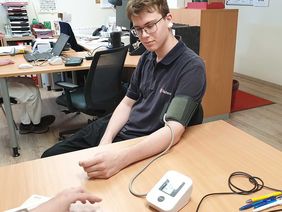 Bei einem jungen Mann wird der Blutdruck gemessen.